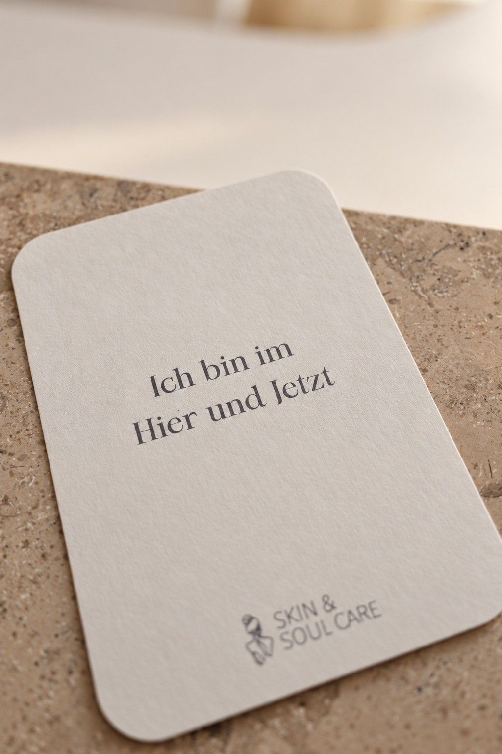 Karte mit dem Satz „Ich bin im Hier und Jetzt“ und dem Logo auf einem Tresen aus Naturstein