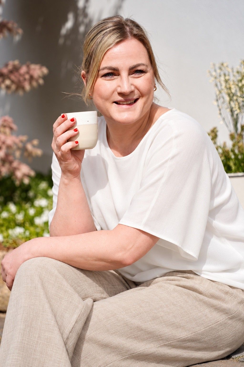 Maike Falkenberg mit einer Tasse in der Hand in ihrem Studio